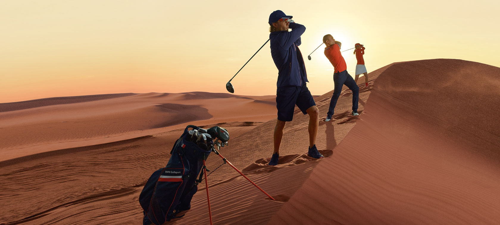 BMW Lifestyle. Mensen golfen in de BMW Golfsport Collection, op de voorgrond staat de BMW Golfsport draagtas.